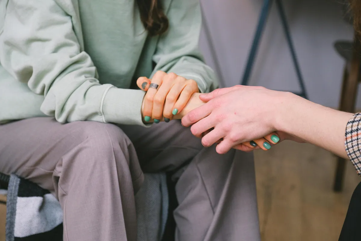 Two people holding hands in a caring moment