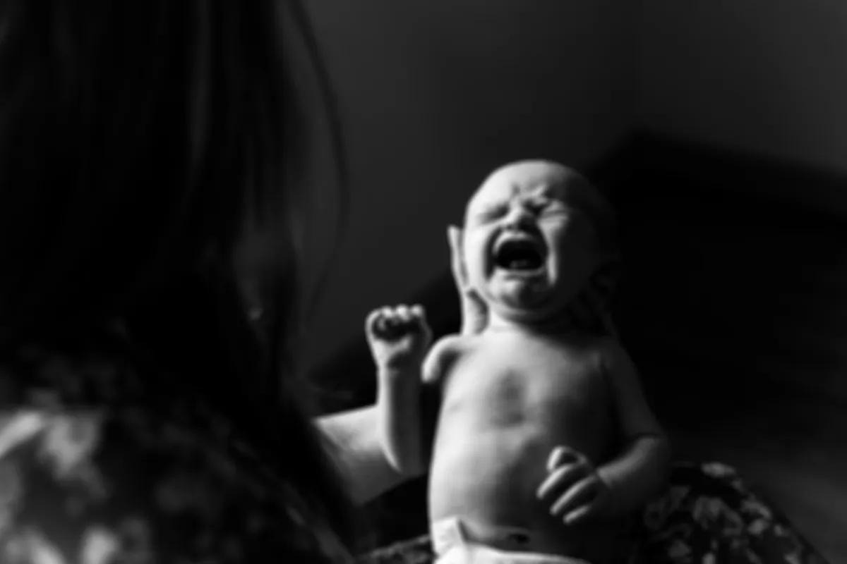 A newborn baby laughing in black and white
