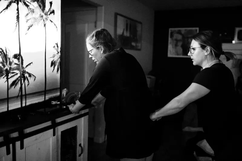 A doula supporting a mother during labor in black and white